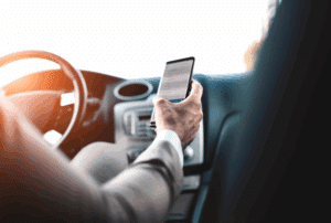 Image is of a driver looking at their phone while driving, concept of myths about distracted driving