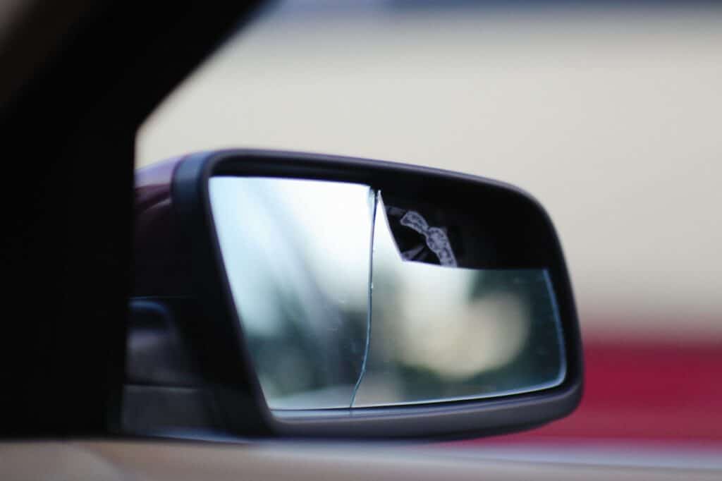 Damaged side mirror showing vehicle impact from a car accident.