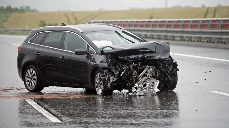 Damaged car after a crash on a wet highway showing how rain contributes to car accidents in TN.