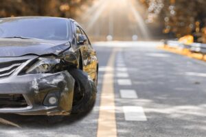 Image shows a heavily damaged car on the side of the road, concept of hit-and-run accidents in Murfreesboro and how victims face sudden financial and legal challenges.