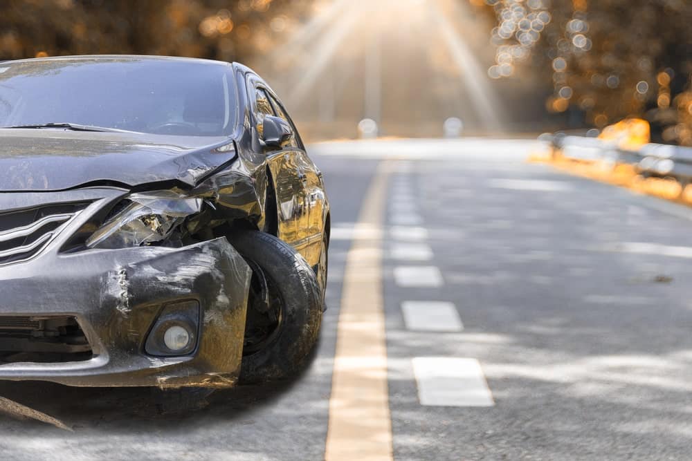 Image shows a heavily damaged car on the side of the road, concept of hit-and-run accidents in Murfreesboro and how victims face sudden financial and legal challenges.