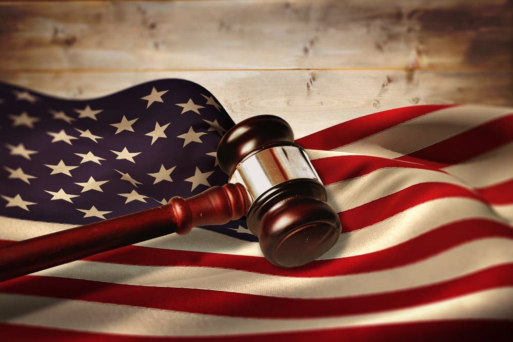Image shows a judge’s gavel placed on the American flag, symbolizing U.S. trucking laws and accident claims