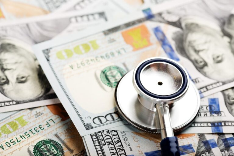 Image shows a stethoscope placed on several hundred dollar bills, representing the medical expenses that arise after a Tennessee motorcycle crash.