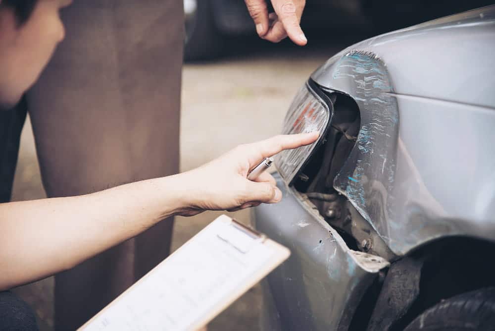 Image is of a damaged rear vehicle being inspected after a collision, concept of injury claims in Tennessee and accident evidence evaluation