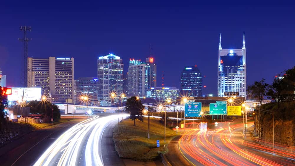 Image is of the Nashville skyline at night with highway traffic, representing the location context of a motorcycle accident in TN.
