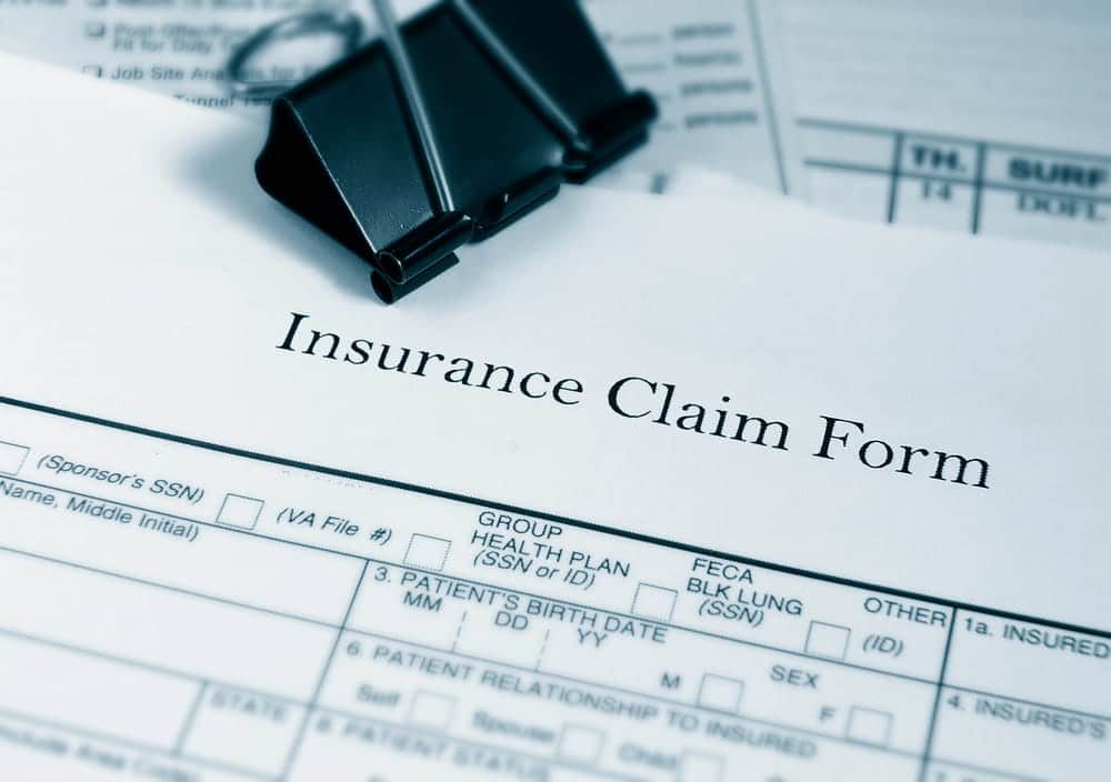 Image is of an insurance claim form with documents, representing compensation steps after a Jackknife Truck accident in Murfreesboro