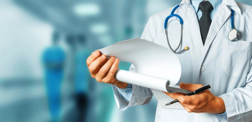 Image is of a medical professional reviewing injury records for courtroom testimony, concept of car accident claims.