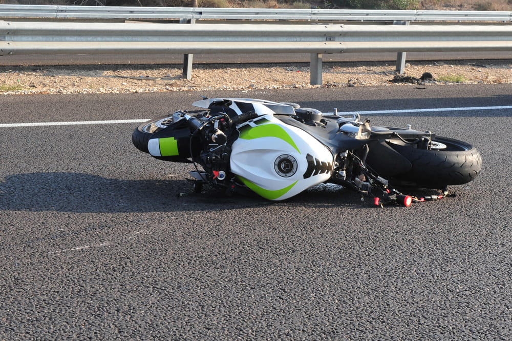 Image is of a motorcycle lying on the roadway after a collision, concept of a motorcycle accident and DUI investigation in Tennessee.