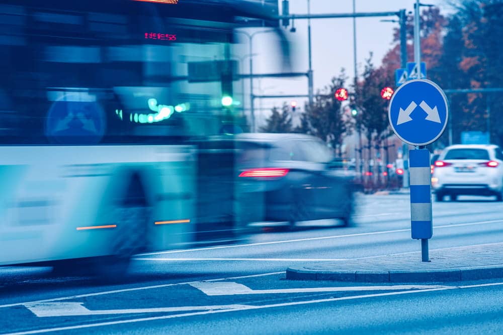Image is of vehicles moving through a busy intersection, concept of a car accident caused by inexperience and traffic navigation challenges.