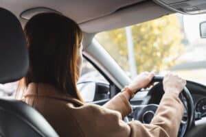 Image is of a young driver operating a vehicle, concept of a car accident involving teen driving decisions and roadway awareness.