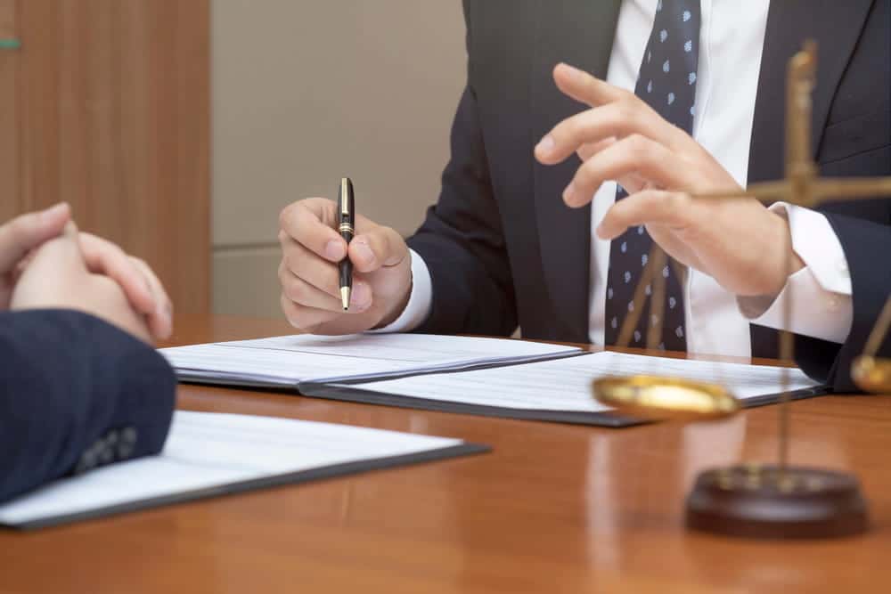 Image is of an attorney meeting with a client, concept of legal guidance for motorcycle passengers who file claims in Tennessee.