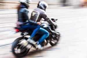 Image is of two people riding a motorcycle, concept of injuries that may lead passengers to file claims in Tennessee.