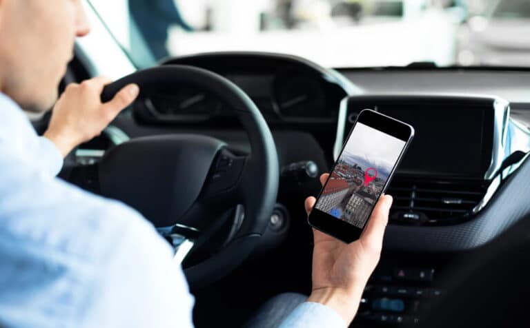 Image is of a driver looking at a mobile phone while driving, concept of distracted driving in Tennessee.