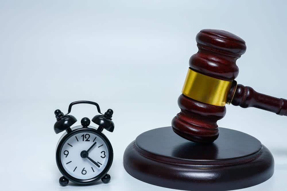 Image is of a courtroom gavel beside a clock, concept of legal time limits for truck accident claims in Tennessee.