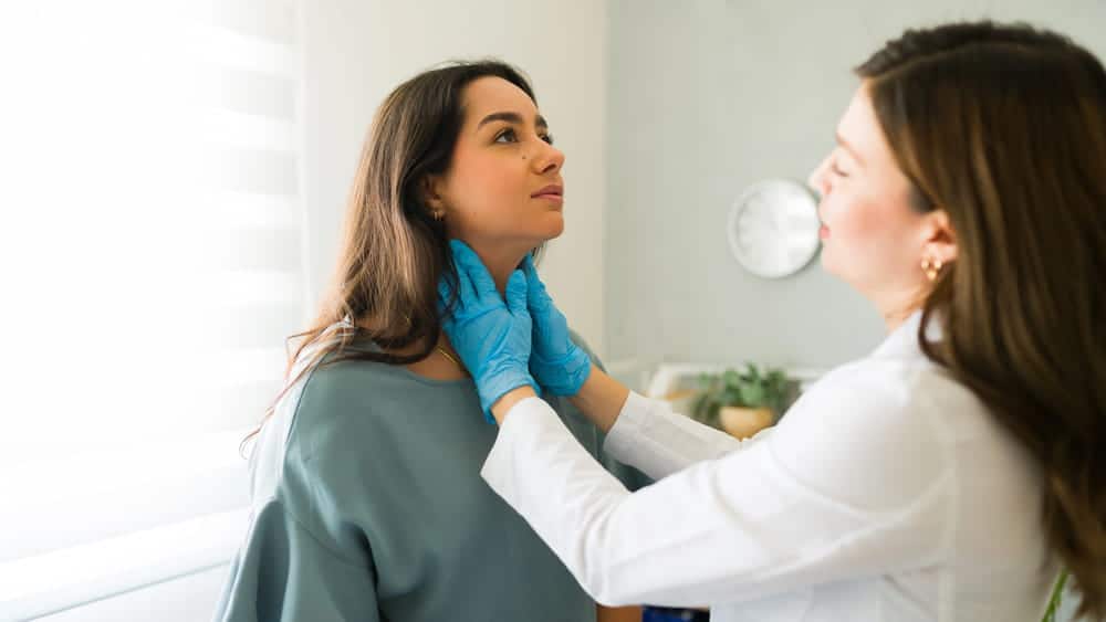 Image is of a doctor examining a woman's neck for pain, concept of delayed pain after a motorcycle accident