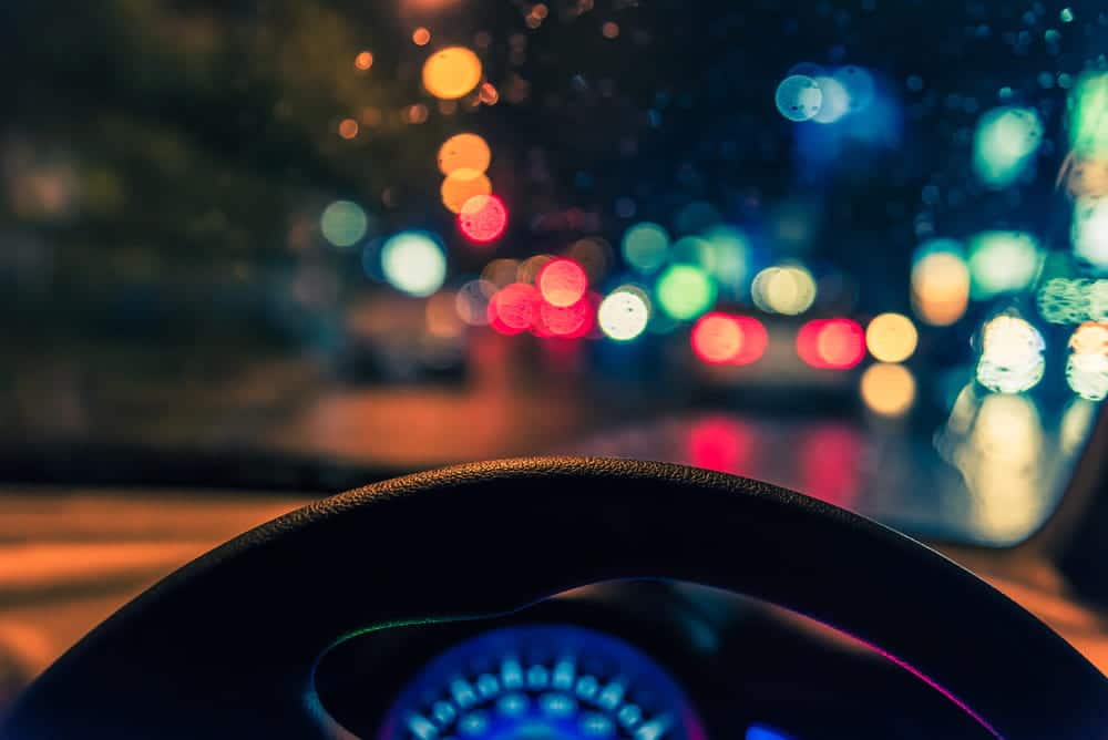 Image is of a driver traveling through rainy nighttime traffic, concept of reduced visibility and holiday driving risks in Murfreesboro.
