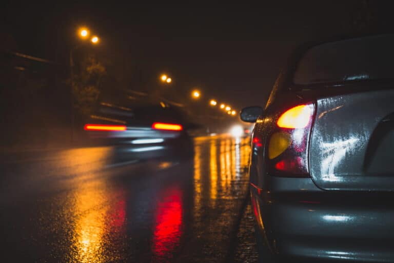 Image is of cars traveling on a wet road at night, concept of poor weather and holiday driving risks in Murfreesboro.