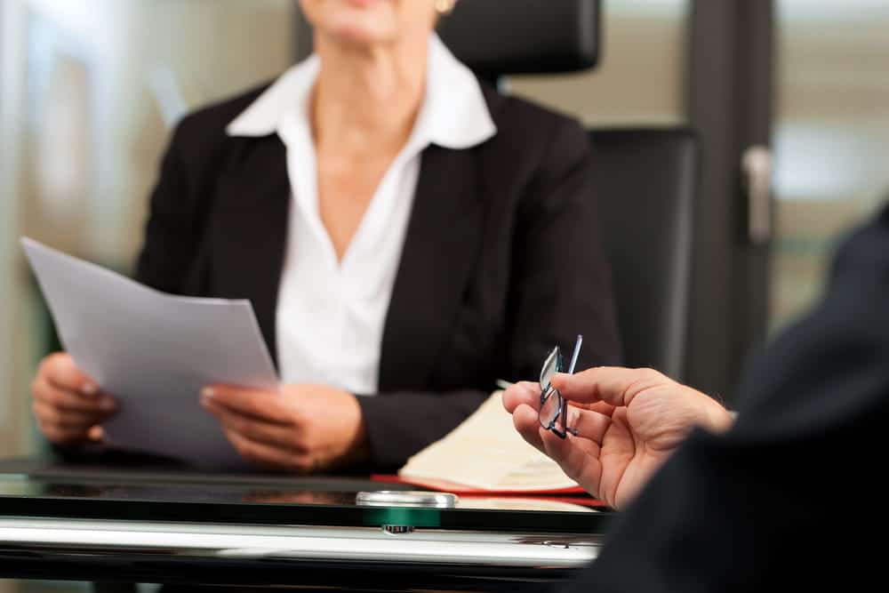Image is of two people reviewing legal documents, concept of protecting your rights after a car accident in TN.