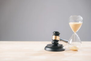Image is of a wooden judge's gavel next to a glass hourglass, concept of the statute of limitations for a car accident claim in Tennessee.